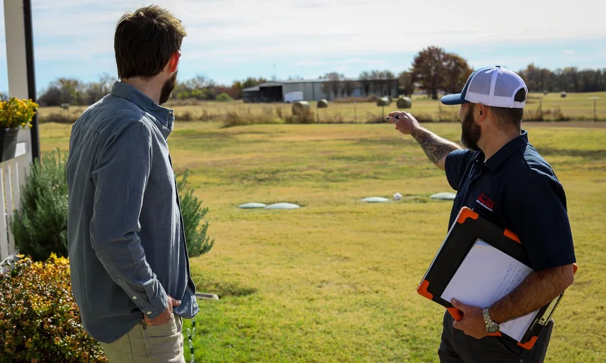 HomeField technician pointing across a property with a homeowner