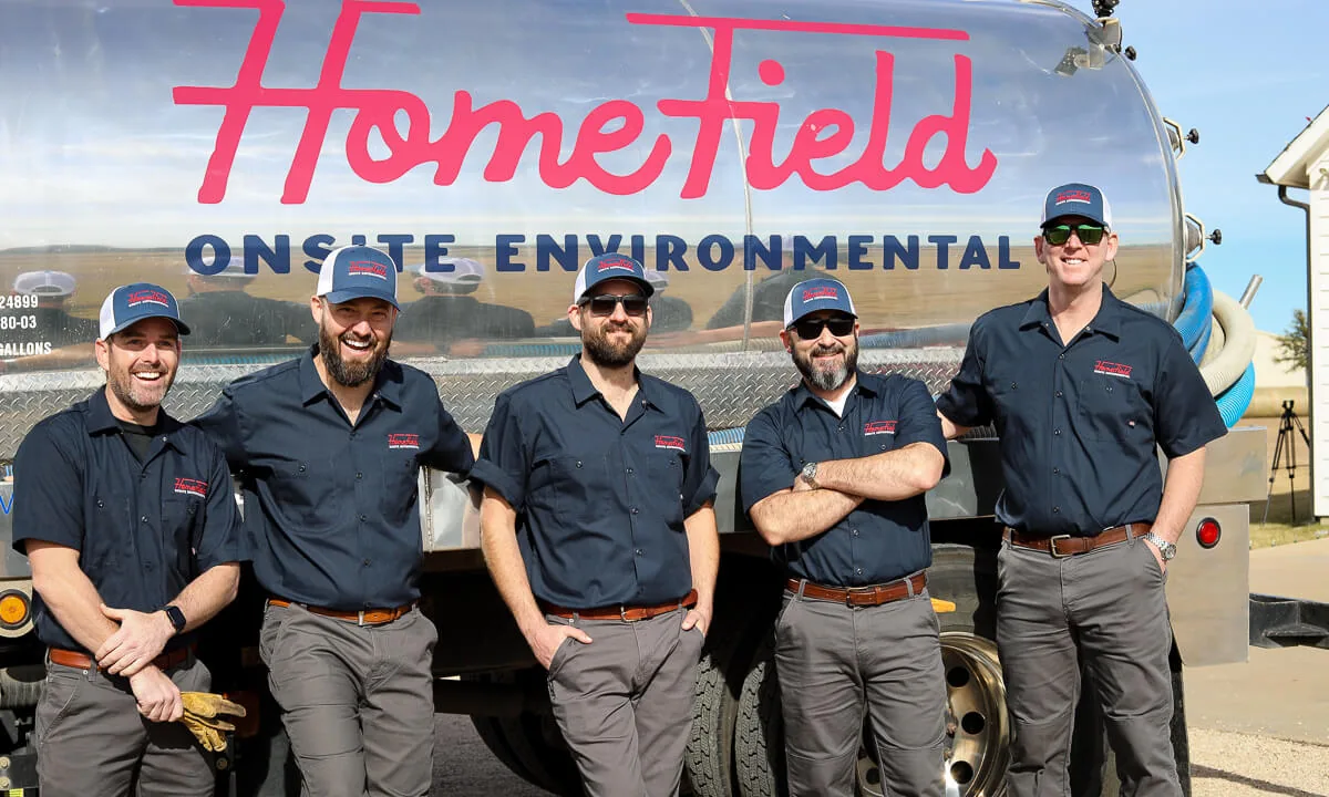 Five HomeField crew members standing in front of a pump truck
