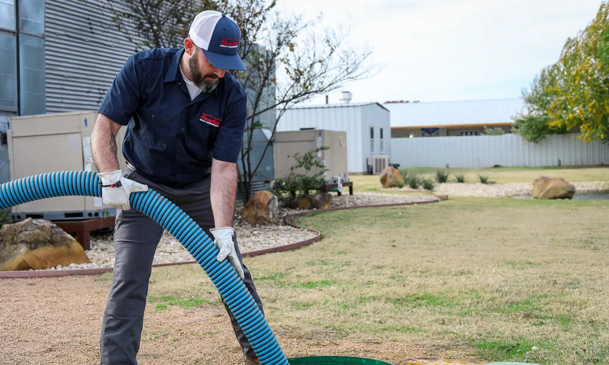 Technician feeding a hose into a riser at a commercial building